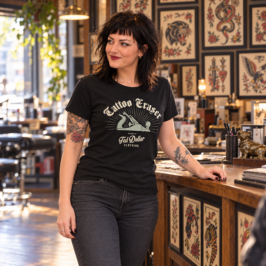 T-shirt femme Tattoo Eraser Ted Dollar porté par une brune tatouée dans un salon de tatouage